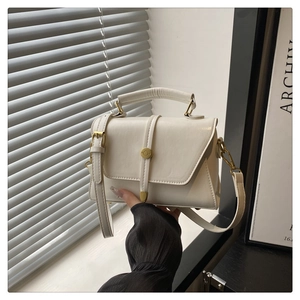 Detail of white glossy PU leather mini handbag with gold hardware and flap closure