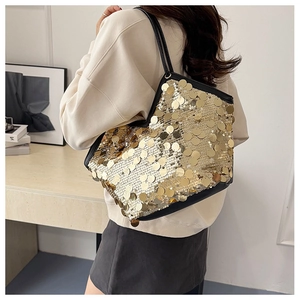 Detailed view of shimmering gold sequins on a stylish shoulder bag with black strap