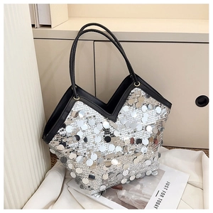 Detailed close-up of sparkling silver sequins and black handles on a fashion tote bag