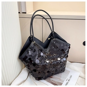 Detailed view of shimmering black large sequins on a stylish V-shaped evening bag