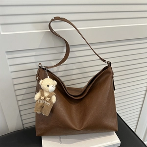 Grande borsa tote in pelle vintage marrone con ciondolo a forma di orsetto su base bianca
