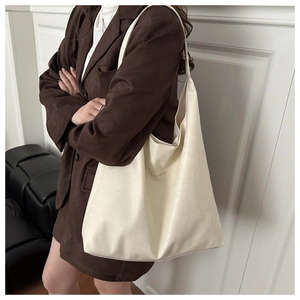 Vue détaillée du cabas en cuir crème avec lettrage doré élégant FASHION sur le devant