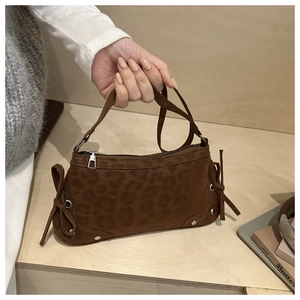 Detail showing brown leopard print texture with drawstring bow and silver rivets on bag