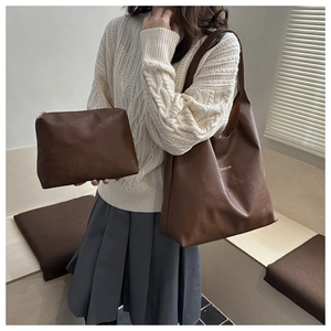 Détail d'un grand sac cabas marron foncé avec pochette assortie et lettrage doré