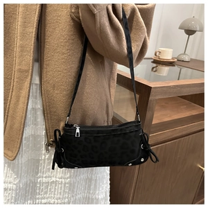 Detail of black leopard jacquard crossbody bag with silver studs and ribbon bow