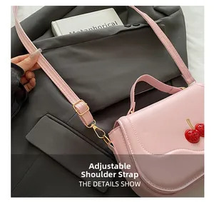 Close-up of the adjustable strap with gold buckles on this pink cherry handbag