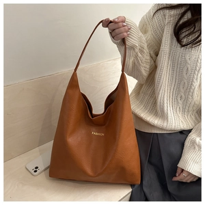 Détail de la texture d'un cabas vintage en cuir marron avec lettrage doré fashion