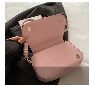 Detailed close-up of pink PU leather bag with golden magnetic snap button closures