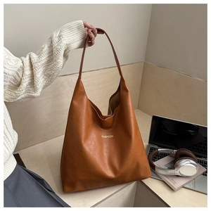 Détail du cabas en cuir PU marron avec texte FASHION doré et large bandoulière