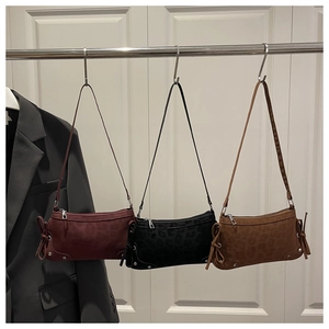 Detailed display of three animal-print bow shoulder bags in burgundy, black, and camel colors