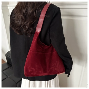 Détail du sac cabas en daim bordeaux avec grandes poches et texture élégante