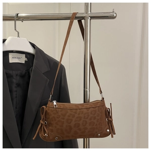 Detail of leopard print shoulder bag featuring suede texture and decorative side tassels