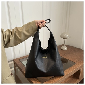 Gros plan d'un grand sac cabas noir texturé avec lettrage doré et intérieur spacieux