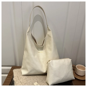Détail d'un ensemble de cabas en cuir crème souple avec lettrage doré et pochette interne