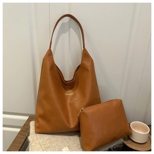 Gros plan du sac cabas marron caramel avec pochette assortie et texture grainée délicate