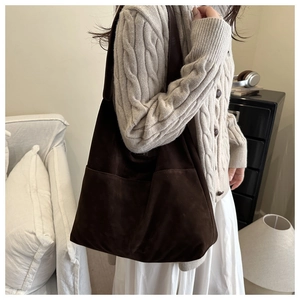 Détail d'un sac cabas en daim marron foncé avec poche latérale et grande capacité d'épaule