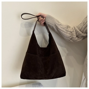 Détail d'un grand sac bandoulière en daim marron avec poignée pour la mode d'automne