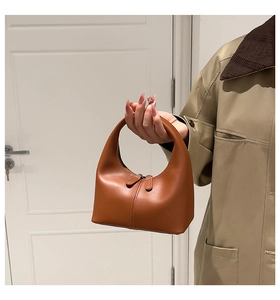Detail of brown leather hobo bag featuring smooth texture and dual zipper closure