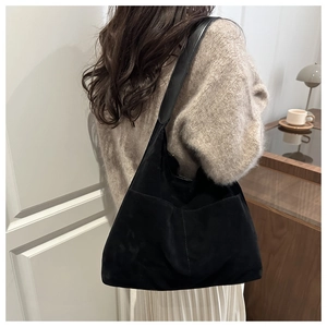 Détail du grand sac cabas en daim noir mat montrant la texture et la bandoulière large