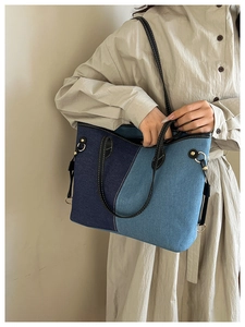 Detail of color-block denim tote with gold hardware and adjustable leather strap