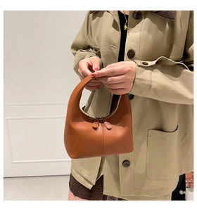 Detail view of cognac crescent handbag showing the smooth leather texture and stitching