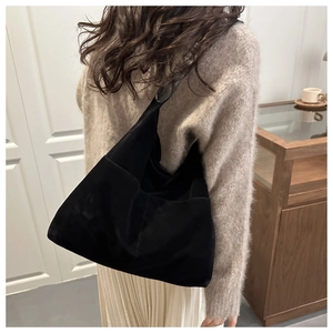 Sac fourre-tout noir mat porté par un mannequin dans un intérieur élégant