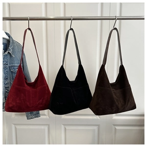 Détails de trois sacs portés épaule en daim en bordeaux, noir et marron foncé