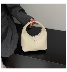 Detail view of cream crescent hobo bag featuring double zippers and smooth leather texture