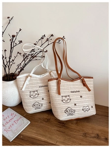 Détail du sac fourre-tout tissé avec broderie de chat et sangles en similicuir chic