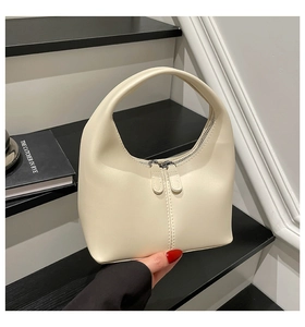 Close-up of a creamy beige PU leather hobo bag featuring dual silver zippers and smooth texture