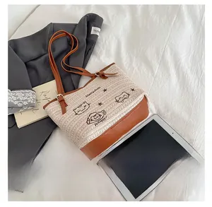 Détail du sac fourre-tout tissé avec broderie de chat et bandoulière en cuir réglable