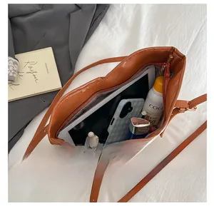 Intérieur spacieux du sac cabas tissé montrant les finitions en cuir et les accessoires