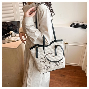 Détail du sac cabas tissé avec broderie de chat et fines bandoulières en cuir noir