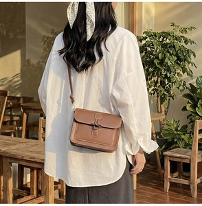 Brown vintage faux leather crossbody bag with white contrast stitching and unique buckle
