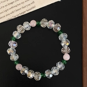 Bracelet en pierres naturelles roses et vertes avec cristaux facettés sur fond noir