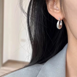 Minimalist silver teardrop hoop earrings with high polish finish for a modern look