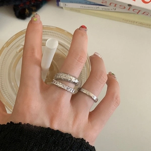 Gros plan d'un ensemble de trois bagues en argent avec zircon sur la main d'un modèle