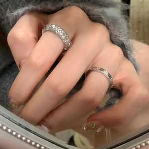 Détail d'une bague tressée argentée avec zircons et motif étoile portée à la main