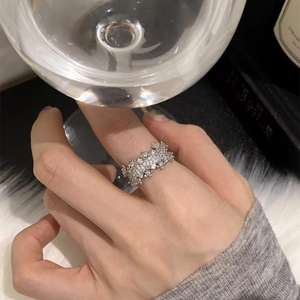 Macro di anello a fascia larga in argento con pavé di zirconi sul dito di una donna