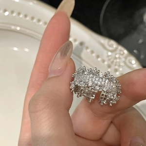 Dettaglio ravvicinato di un anello in argento con zirconi e fascia aperta regolabile
