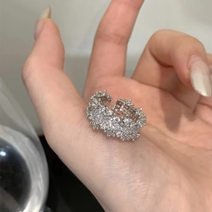 Dettaglio macro di un anello geometrico argento con pavé di pietre di zirconia lucenti