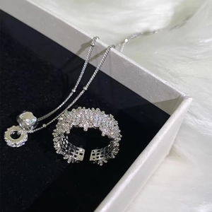Dettaglio di anello e collana in zirconi argentati in una scatola di velluto nero