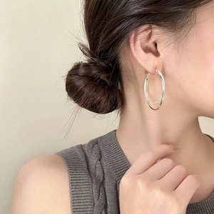 Detail of silver double hoop earrings with one pave set ring on a model side profile