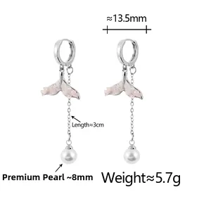 Close-up of fishtail drop earrings with pink texture and elegant high-gloss white pearls