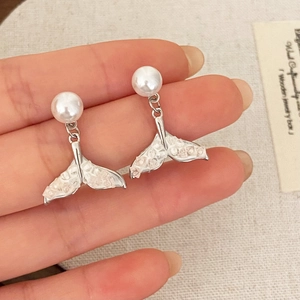 Detail of silver fish tail earrings with white pearl and sparkling crystal inlay