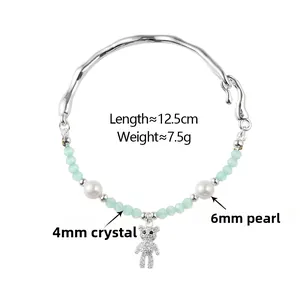 Détails du bracelet de perles avec perles blanches, cristaux verts et pendentif ours