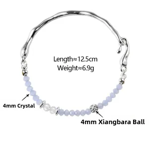 Détail du bracelet argenté avec perles de cristal bleu clair et boule pavée étincelante
