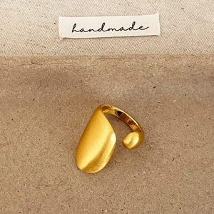 Bague ouverte asymétrique dorée avec finition brossée et perle polie au style minimaliste