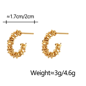 Detail of C-shaped gold hoop earrings with textured finish and measurement markings