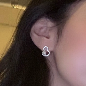 Boucles d'oreilles gourde élégantes avec zircons et perle portées sur le mannequin